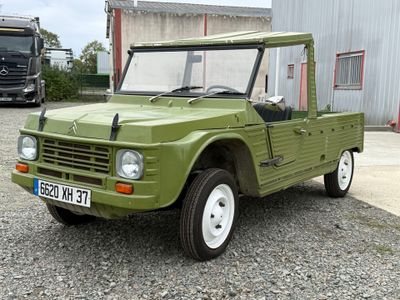 un camion vert garé devant un immeuble