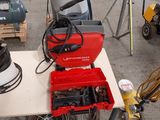 une boîte à outils rouge posée sur une table, à côté d'autres outils