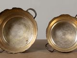 pair of silver plated bowls with handles on a table