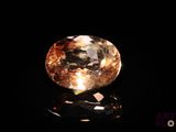 a close up view of a yellow diamond on a black surface