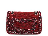 a close up of a red and black purse on a white background