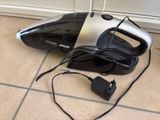 a black and silver vacuum on the floor next to a mouse