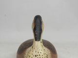 a close up of a wooden duck on a white surface