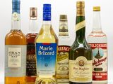 several bottles of alcohol are lined up on a white surface