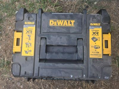 un gros plan d'une boîte à outils posée par terre dans l'herbe