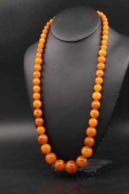 un collier de perles orange sur un mannequin noir