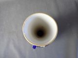 a white cup with a purple handle on a table