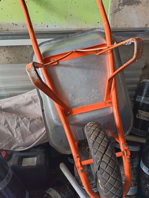 une brouette posée à côté d'un tas d'outils