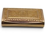 an image of a gold cigarette case sitting on a white surface