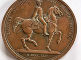 une médaille de bronze représentant un homme à cheval