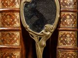 a mirror sitting on top of a book shelf next to some old books