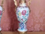 two vases sitting on a table with a pink wallpaper behind them