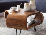 a coffee table with a magazine on it and a vase of flowers on top of it