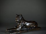 a bronze statue of a lion on a stone base