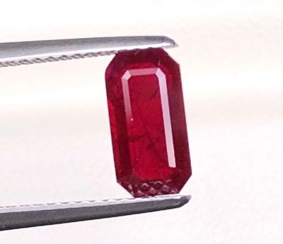 une image montrant un gros plan d'un rubis rouge tenu par une pince