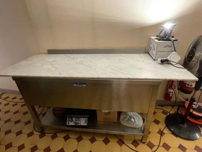 a table with a sink and a fan in a room