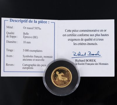 une photo d'une pièce d'or à laquelle est attaché un bout de papier