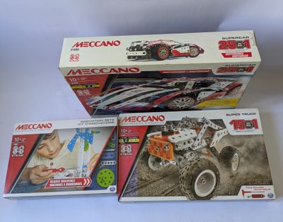 deux boîtes de jouets meccan sur une surface blanche