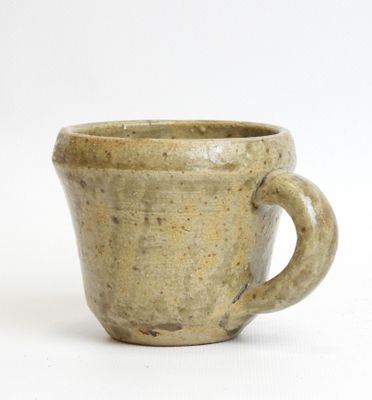 a brown cup with a handle on a white surface