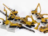 de nombreux engins de chantier miniatures posés sur une surface blanche