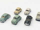 plusieurs petites voitures sont alignées sur une surface blanche