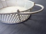 a white basket with a handle on a table