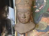 une photo d'une statue posée sur une table, à côté d'une photo d'une femme