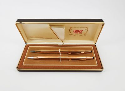 une boîte contenant deux stylos, posée sur une surface blanche