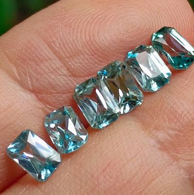 a person holding a piece of blue crystal in their hand