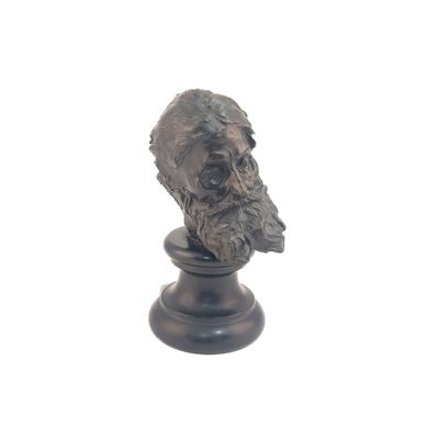 une statue représentant un homme barbu sur un socle