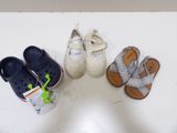 Plusieurs paires de chaussures pour bébé sont alignées sur une table blanche