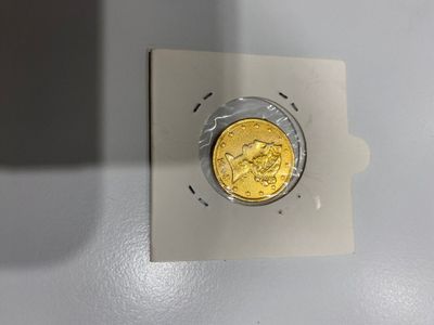 une pièce d'or posée sur un morceau de papier