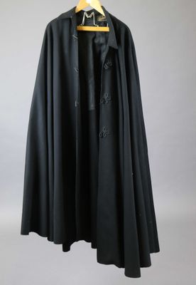 a black cloak is hanging on a wooden hanger