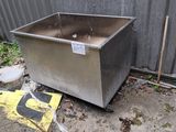 a metal box that is sitting on the ground next to a fence
