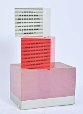 une radio rouge et blanche posée sur une boîte rose et blanche
