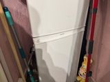 des toilettes blanches et une serpillière rouge dans un coin de la pièce