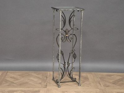 a tall metal stand with a decorative design on it