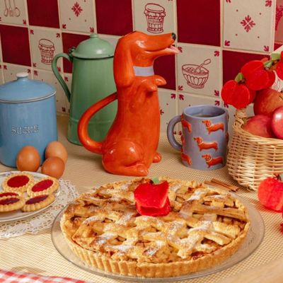 a dog figurine next to a pie on a table