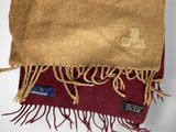 brown and red scarf with gold fringes on a white surface