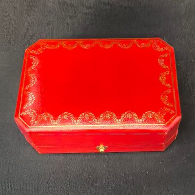 une petite boîte rouge ornée de motifs dorés