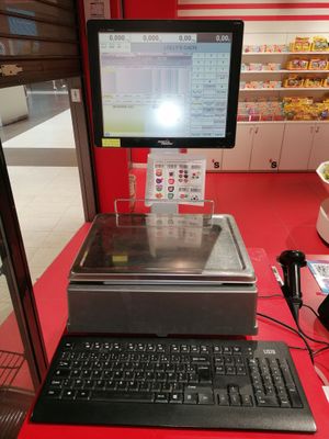 un ordinateur et un clavier posés sur une table rouge dans un magasin