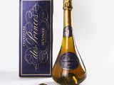 the bottle of champagne is next to a box of chocolates
