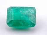 gros plan d'une pierre d'émeraude verte sur une surface blanche