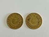two gold coins on a white surface with a white background