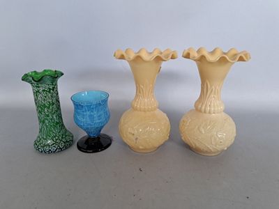 three vases and a glass sitting on a table next to each other