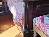 a bed with a foot board and a foot stool in a room