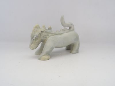 statue d'un éléphant avec un oiseau sur le dos, posée sur une surface blanche