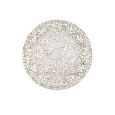 une image représentant une assiette en argent sur laquelle figure un oiseau