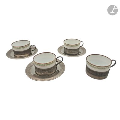 four coffee cups and saucers sitting on a saucer on a white surface