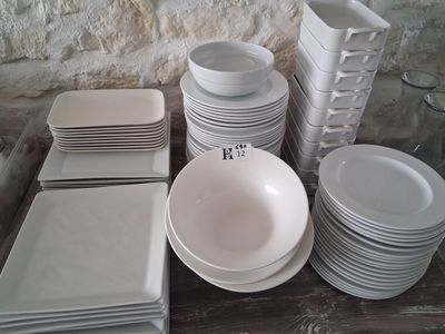 many white plates and bowls on the table